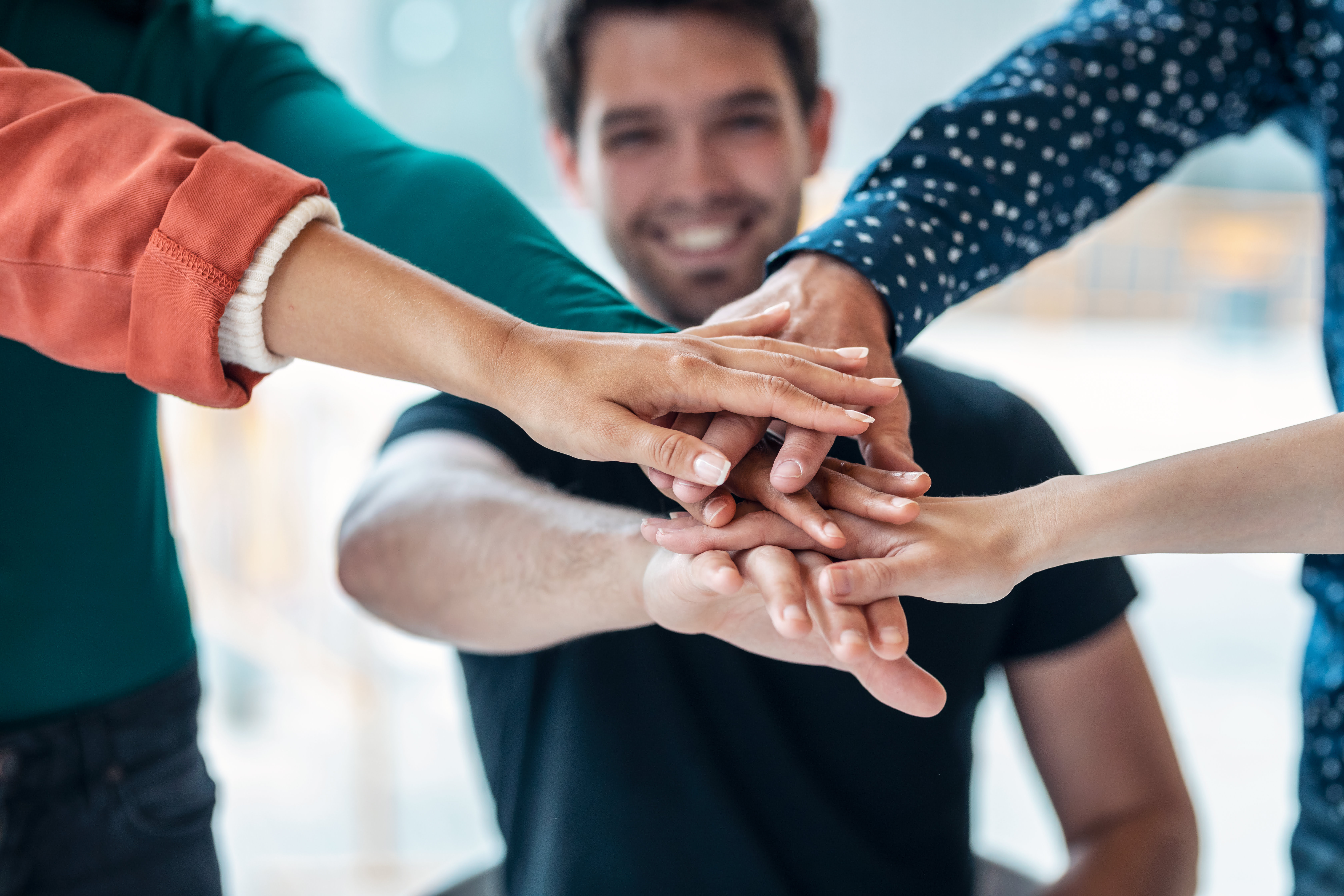 Successful smart business team celebrating good job while holding up their right hands