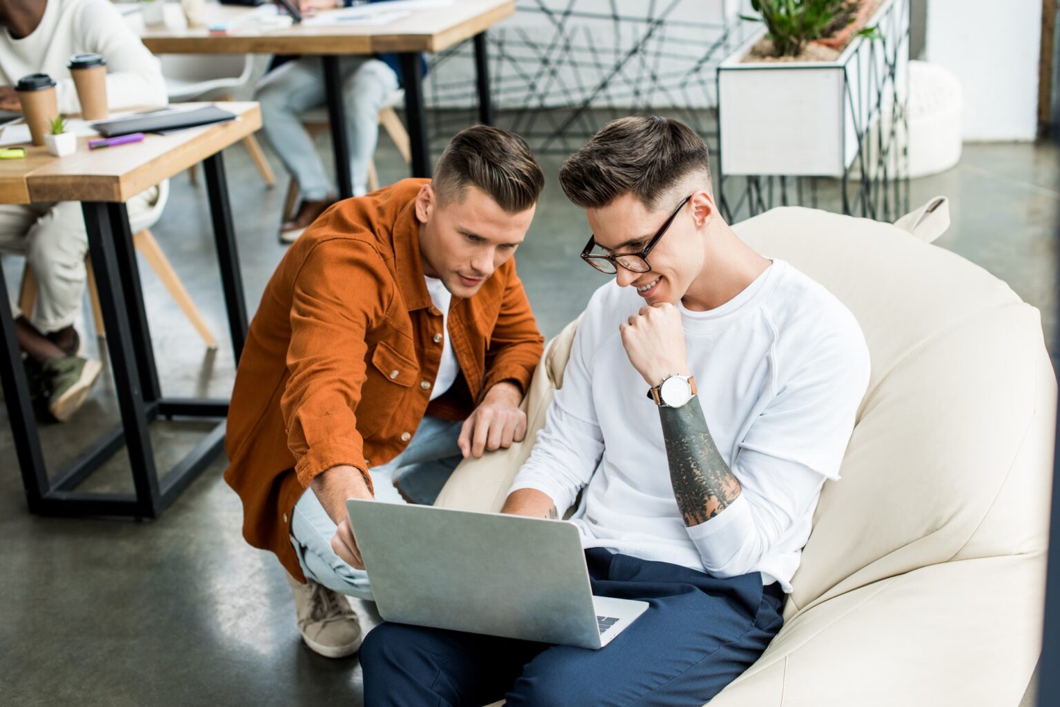 young businessmen looking at laptop while working on startup project together