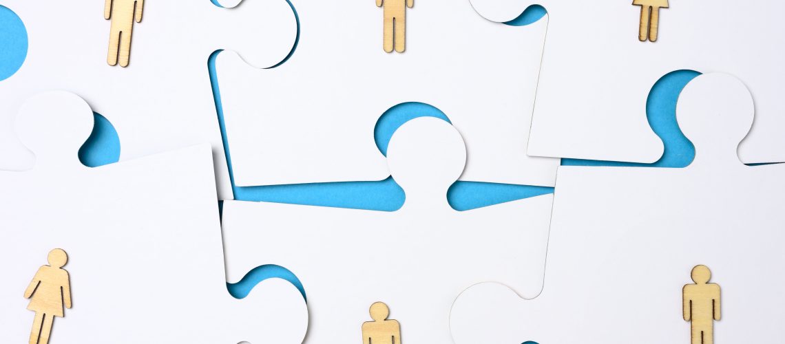 White puzzles and wooden men. Recruitment concept, team compatibility, individuality of each